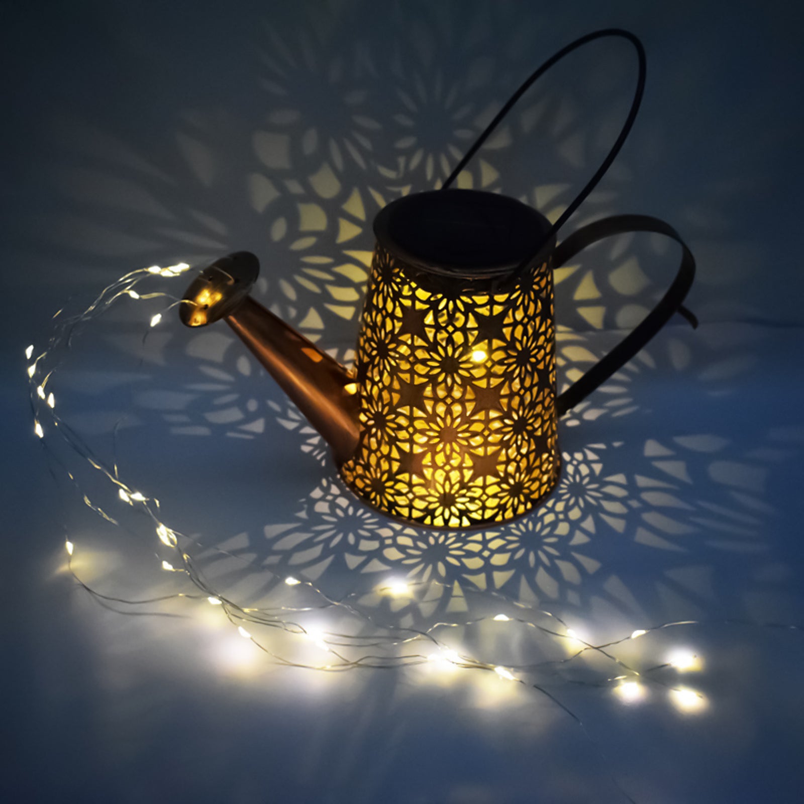 A decorative solar watering can light with LED string lights, hanging on a shepherd hook, illuminating a garden with beautiful patterns.