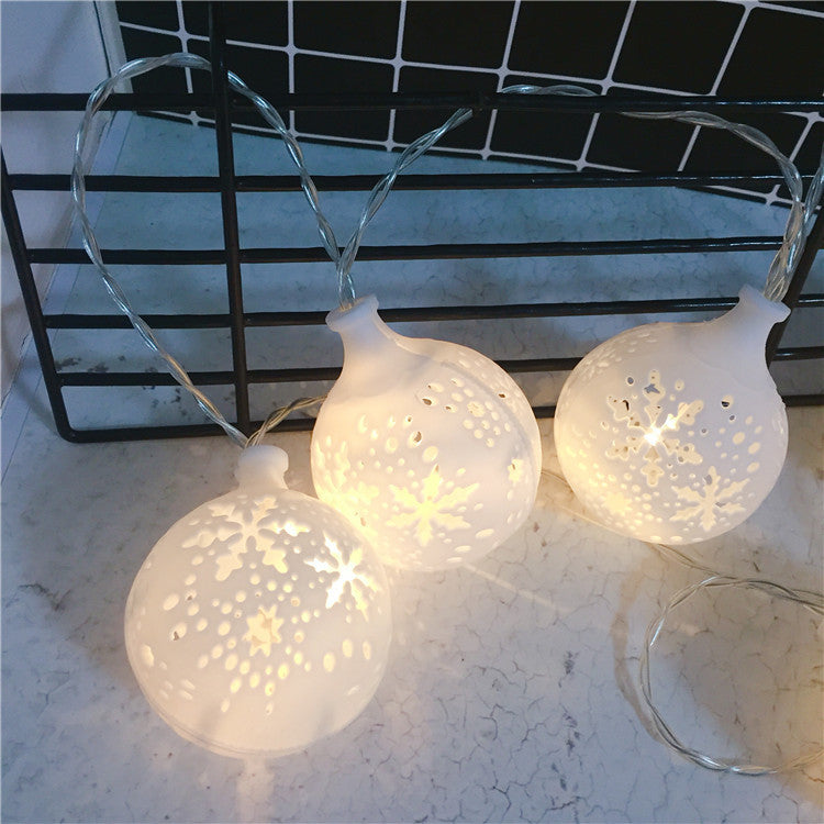 Colorful LED string lights in festive designs, perfect for Christmas and New Year decorations, illuminating a cozy outdoor setting.