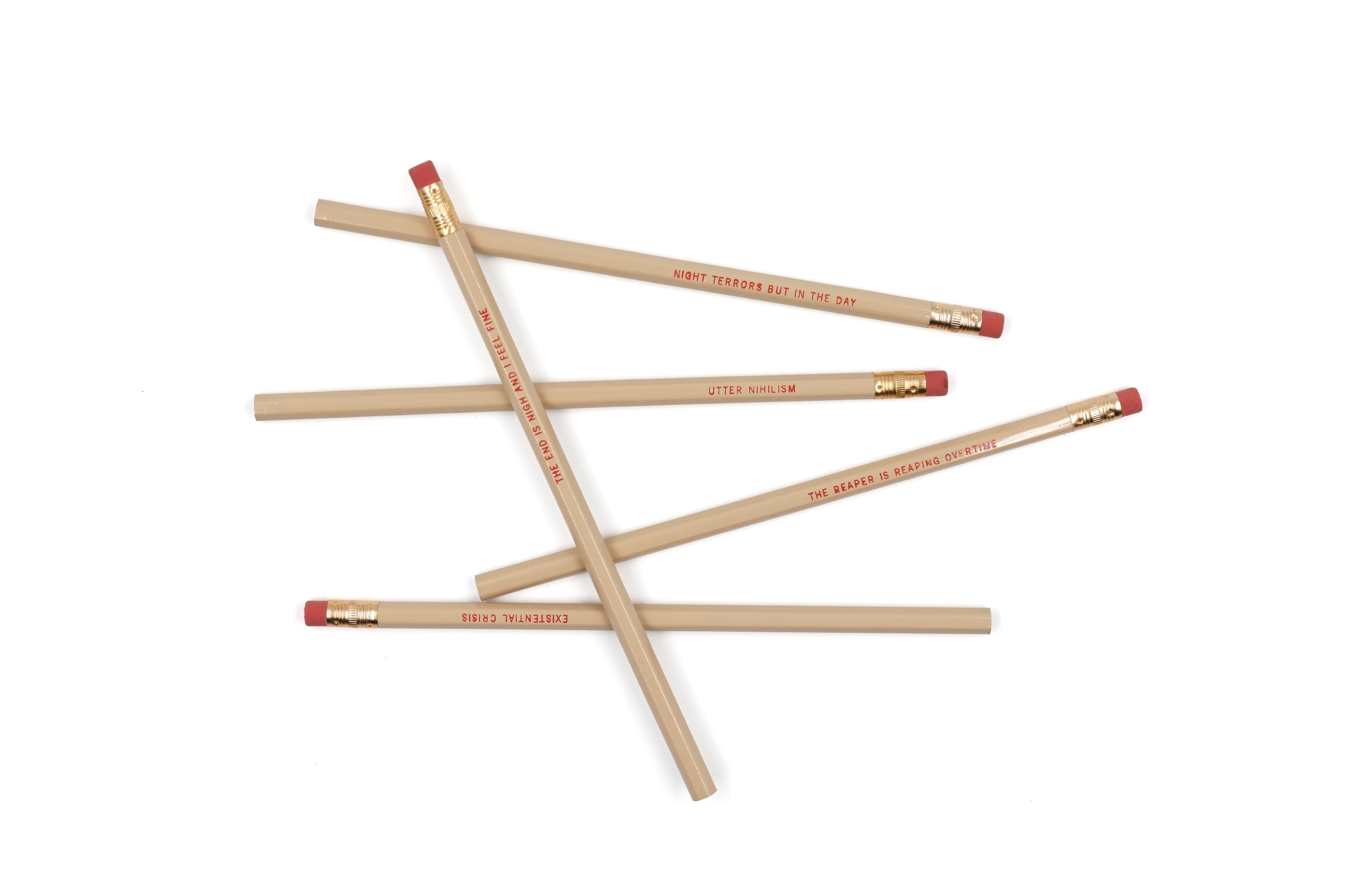 EXISTENTIAL CRISIS Pencil Set featuring five cedar pencils in cream color with blood-red stamped phrases and gold ferrules.