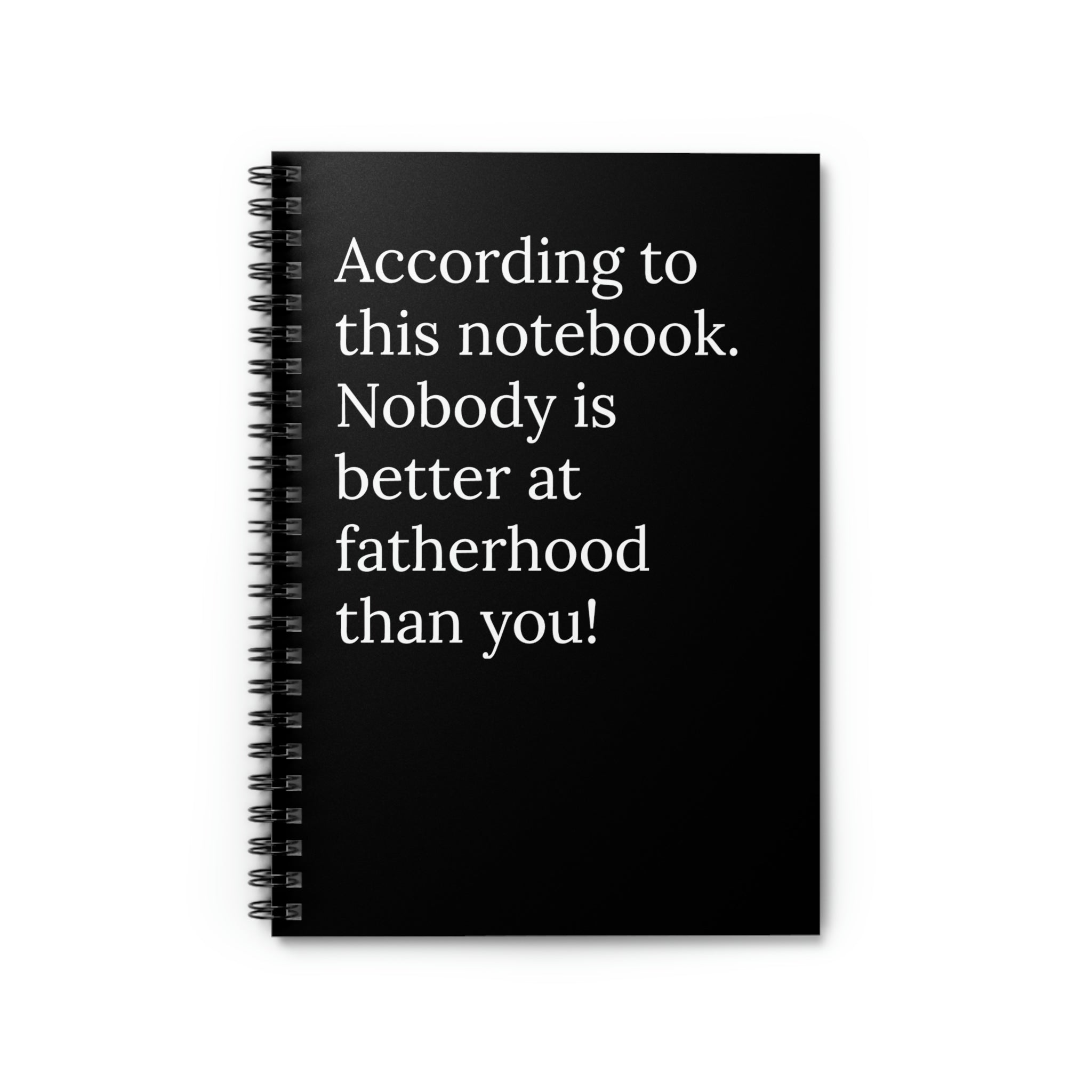A humorous notebook with a printed cover stating 'According To This Notebook Nobody is Better At Fatherhood Than You', featuring a spiral binding and ruled pages.