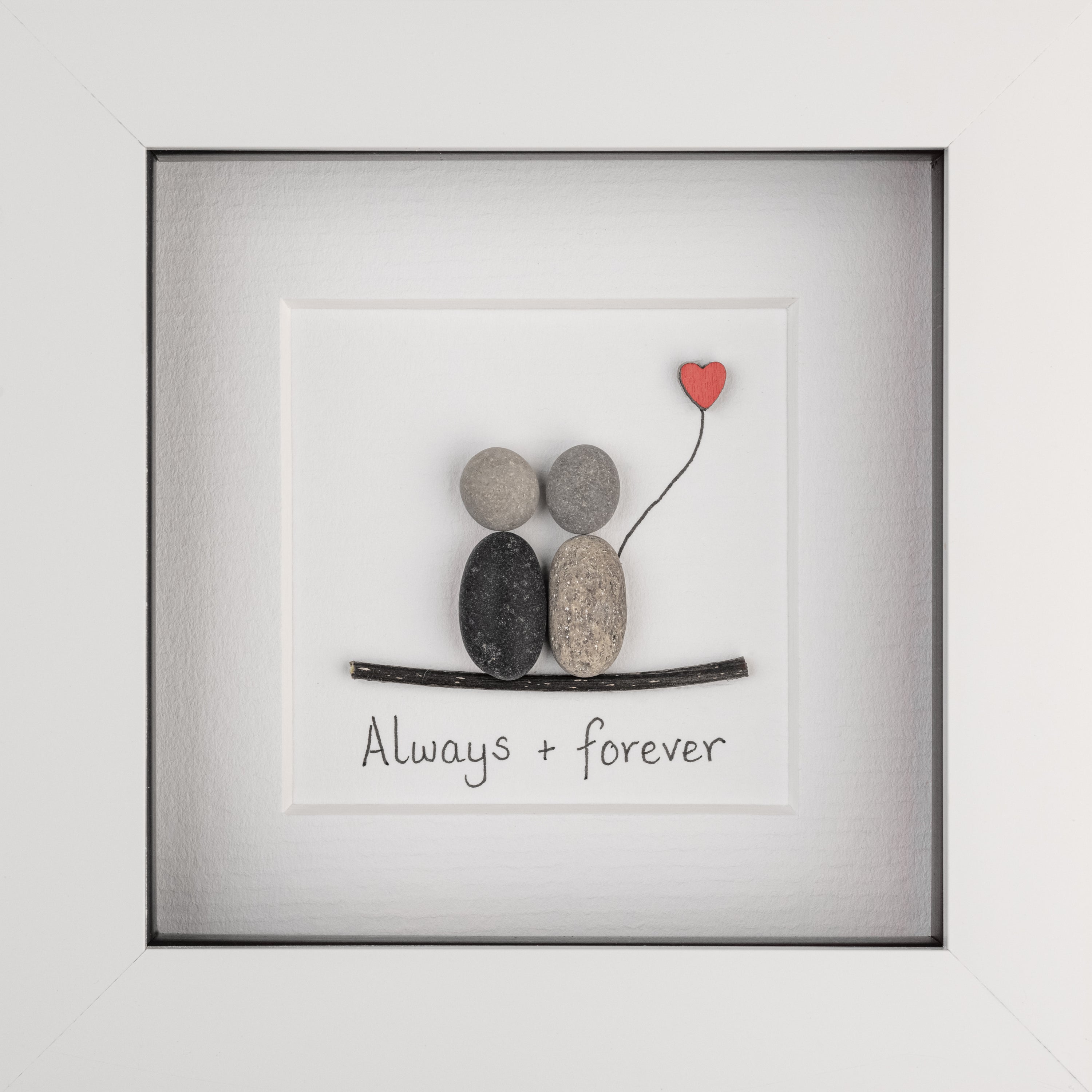 A charming pebble art picture framed in white, depicting a loving couple, symbolizing everlasting love and friendship.