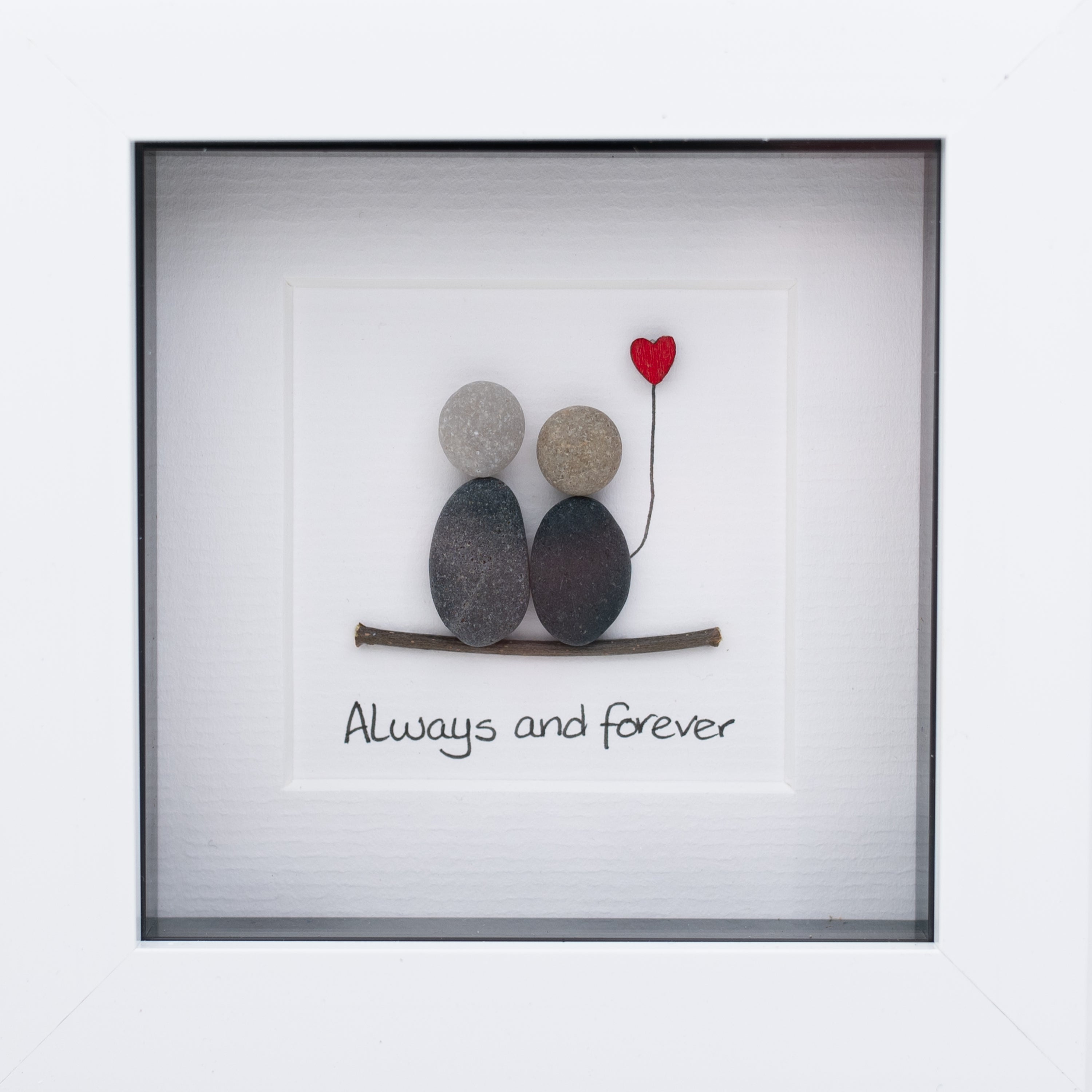 A charming pebble art picture framed in white, depicting a loving couple, symbolizing everlasting love and friendship.