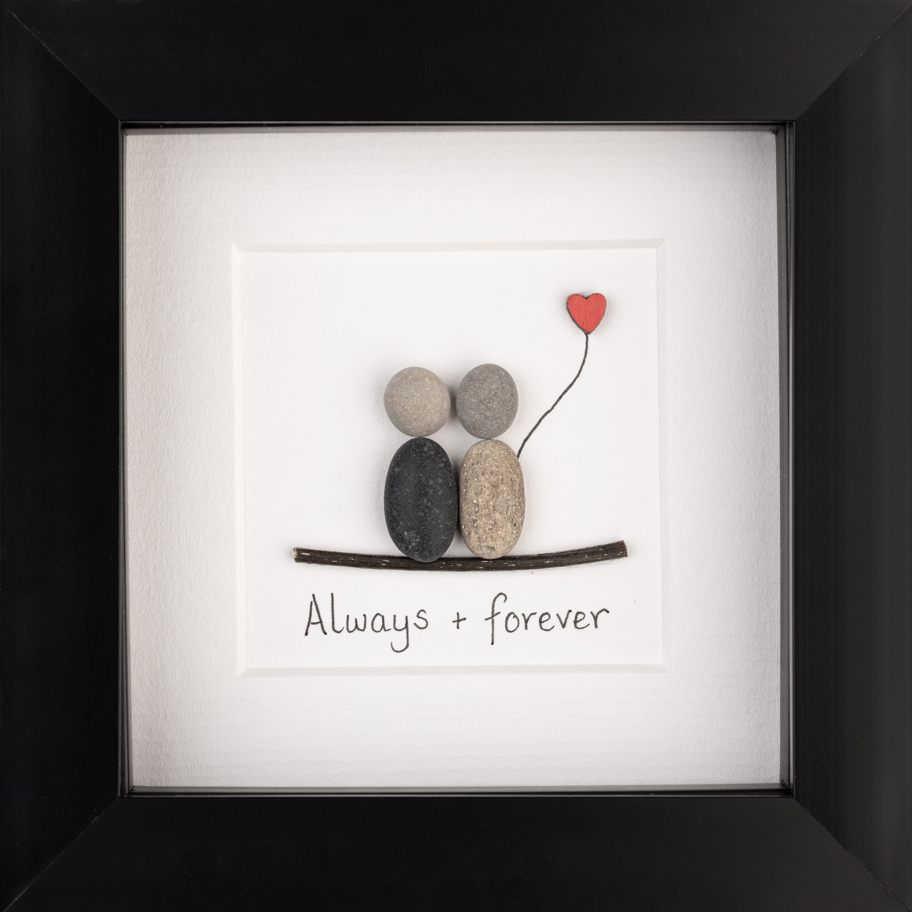 A charming pebble art picture framed in white, depicting a loving couple, symbolizing everlasting love and friendship.