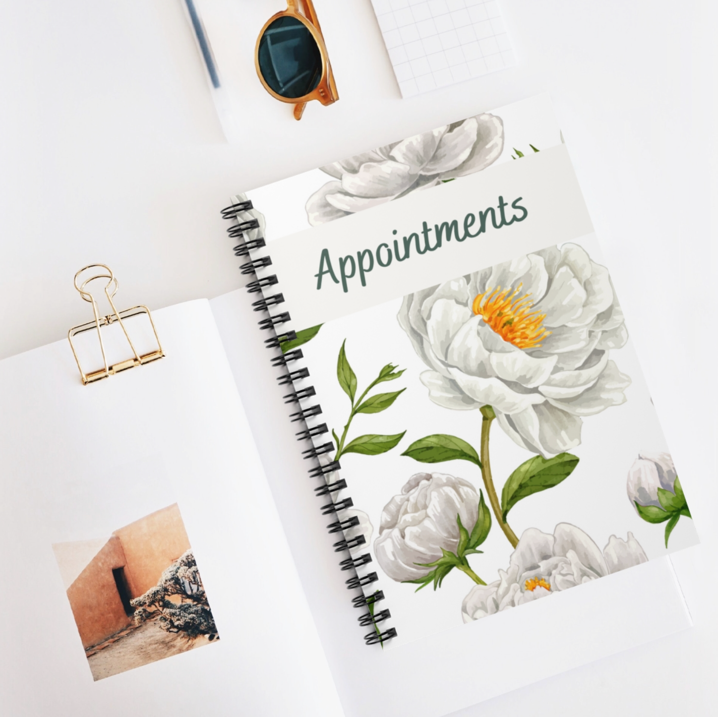 A floral-themed A5 appointment book with a spiral binding and laminated cover, featuring 100 undated pages for versatile scheduling.