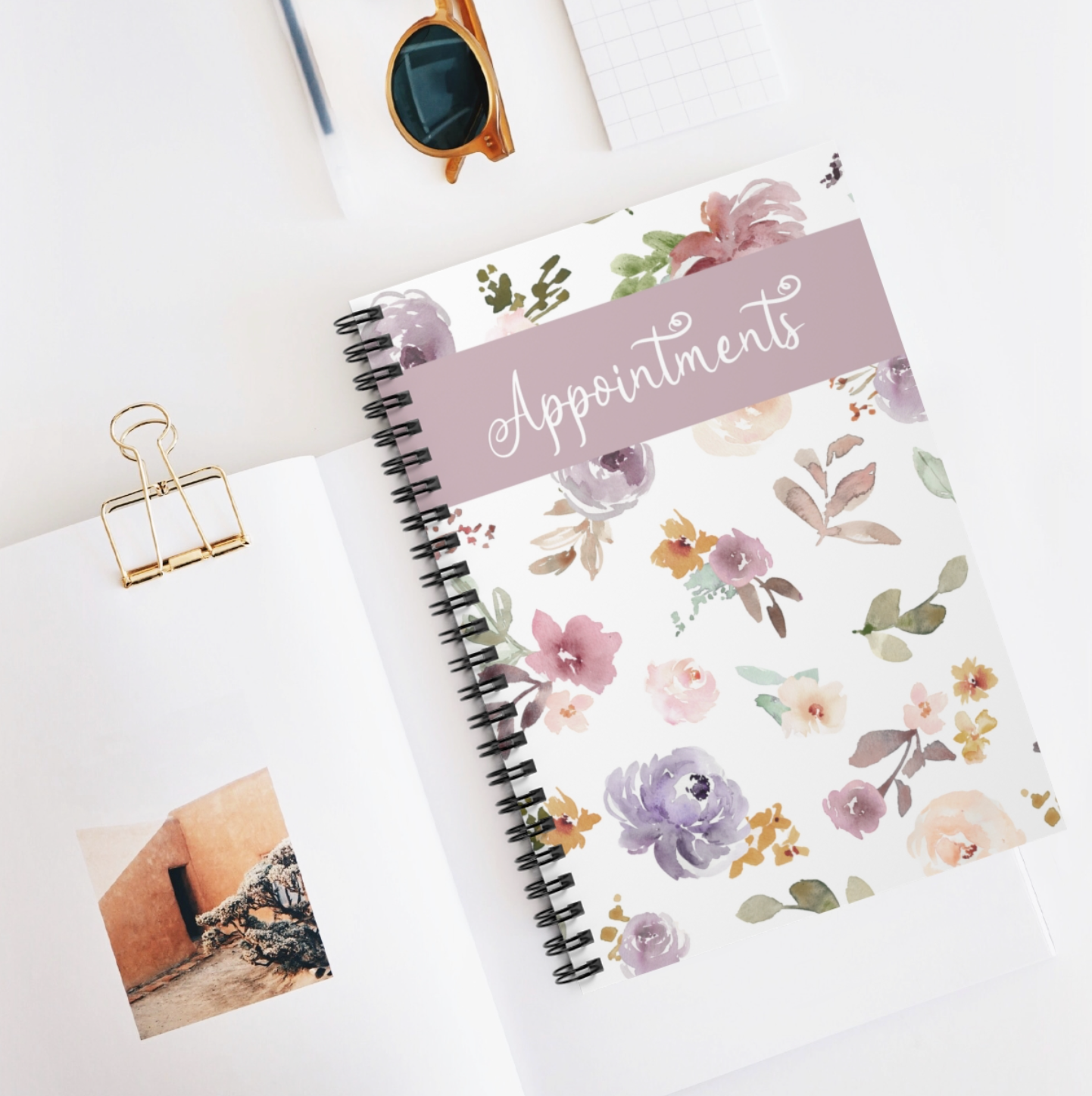 A floral-themed A5 appointment book with a spiral binding and laminated cover, showcasing vibrant flowers on the front.
