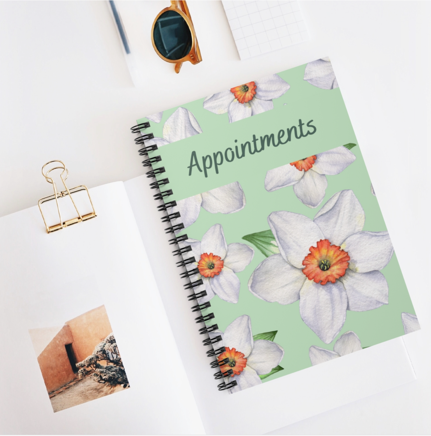 A floral-themed A5 appointment book with a spiral binding and laminated cover, featuring 100 undated pages for versatile use.