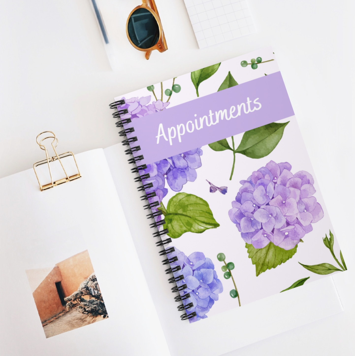 A floral-themed A5 appointment book with a spiral binding and laminated cover, showcasing vibrant flowers on the front.