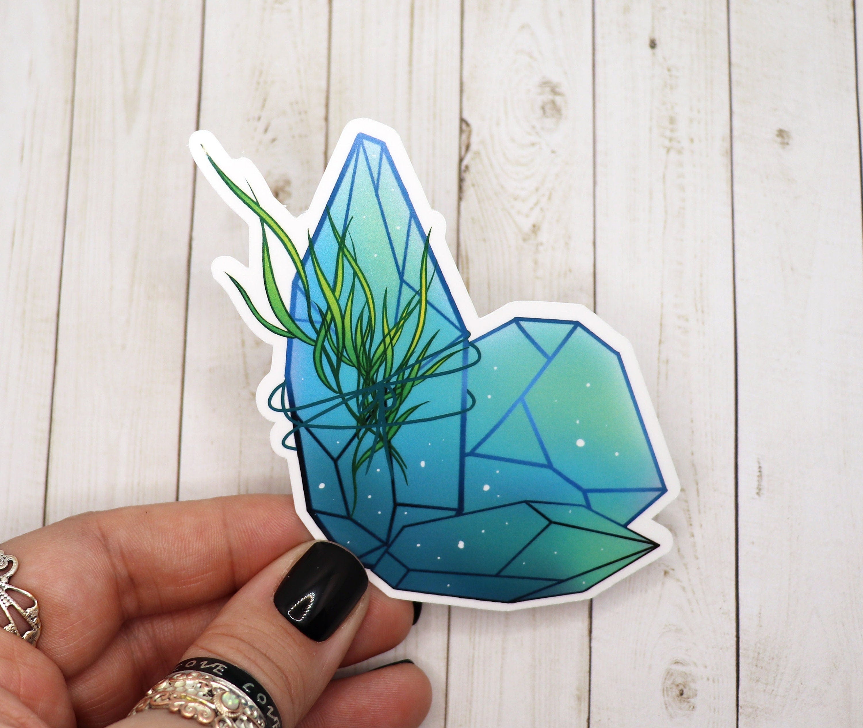 Aqua Sea Crystal Sticker on a white background, showcasing its vibrant colors and intricate design.