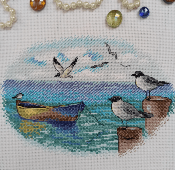 At the Pier M-557 / SM-557 Counted Cross-Stitch Kit featuring Aida canvas, colorful threads, and detailed instructions for crafting.