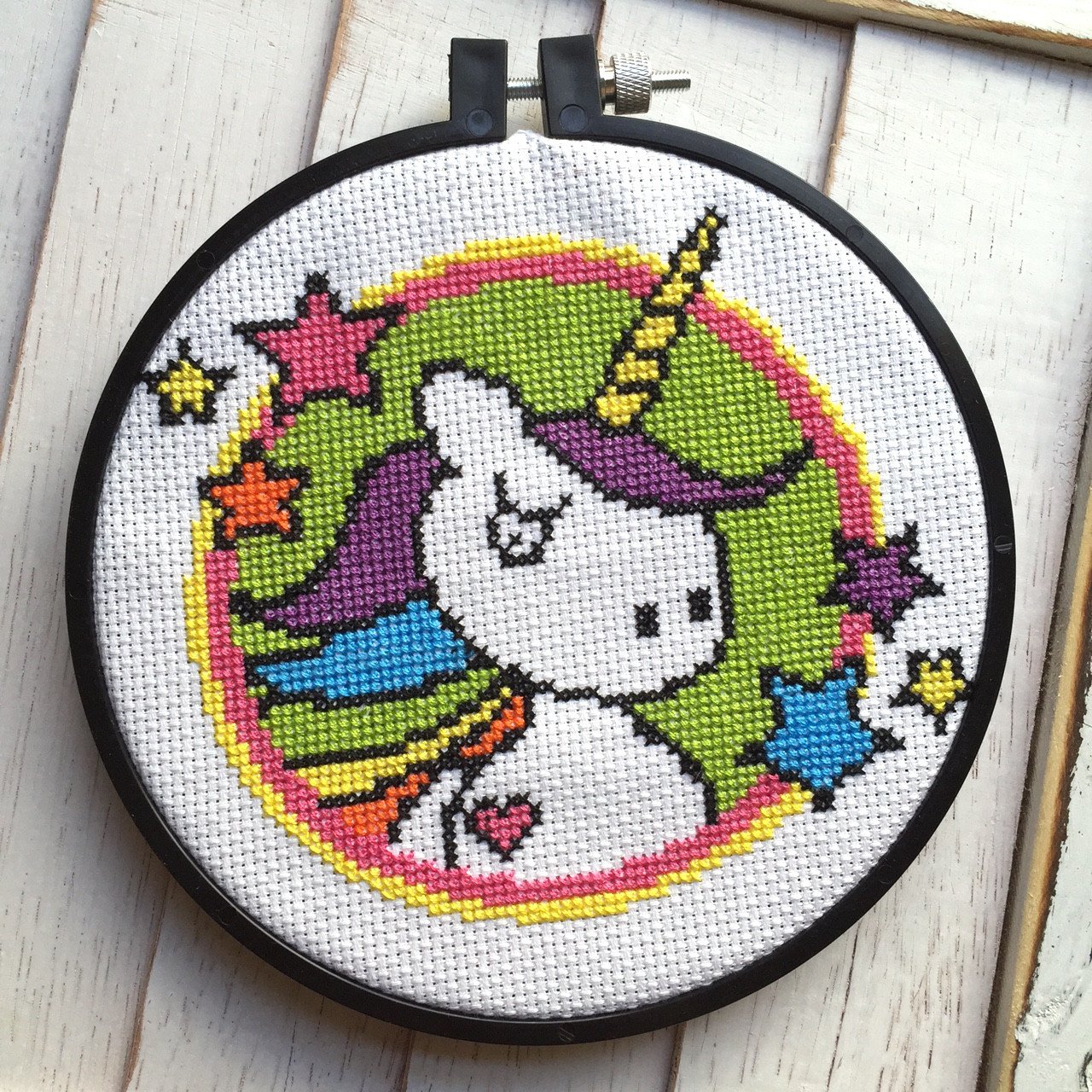 A colorful Badass Unicorn counted cross stitch kit featuring a vibrant unicorn design, complete with all necessary supplies including fabric, threads, and instructions.