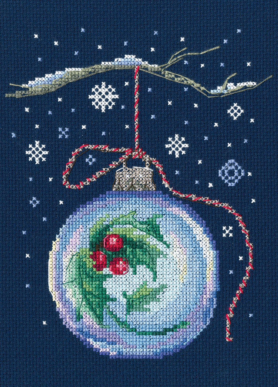 Counted cross stitch kit featuring a ball with a sprig of holly on blue Aida fabric, including threads and needle.