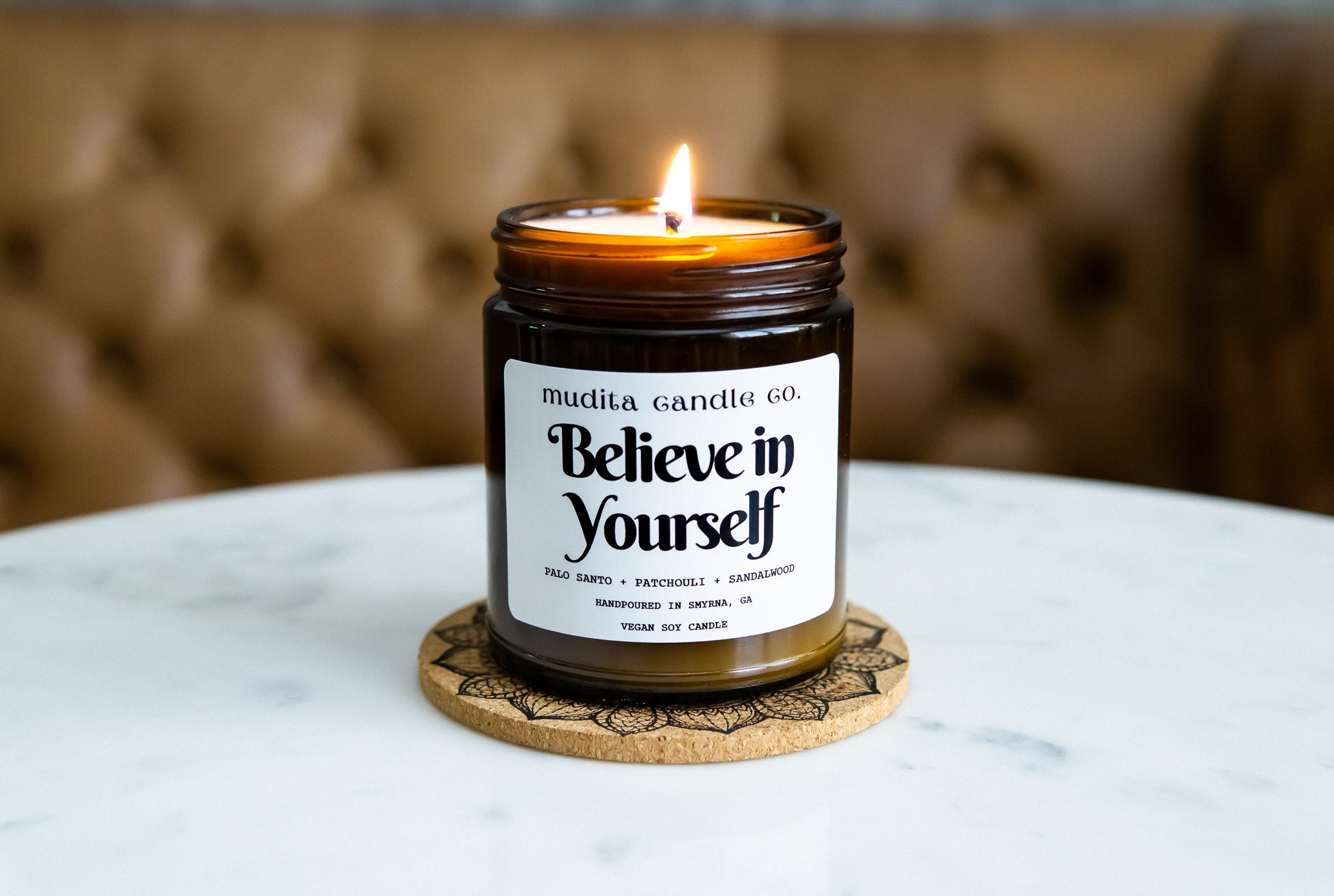 Believe in Yourself candle featuring palo santo, patchouli, and sandalwood scents in a reusable amber glass jar.