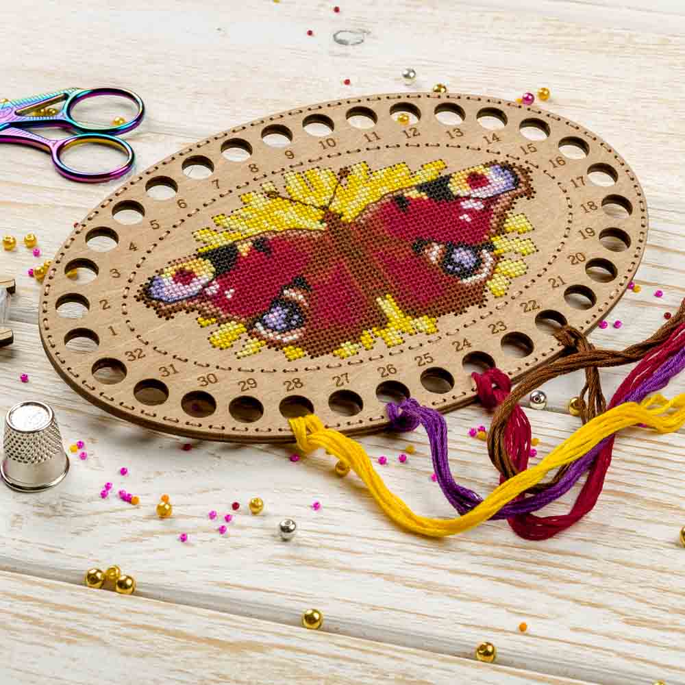 Wooden embroidery blank FLHW-018 with perforated design, thread, and needle for crafting.