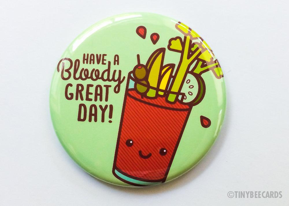 A large 2.25-inch round button featuring a kawaii Bloody Mary illustration with fixings and the text 'Have a Bloody Great Day'.