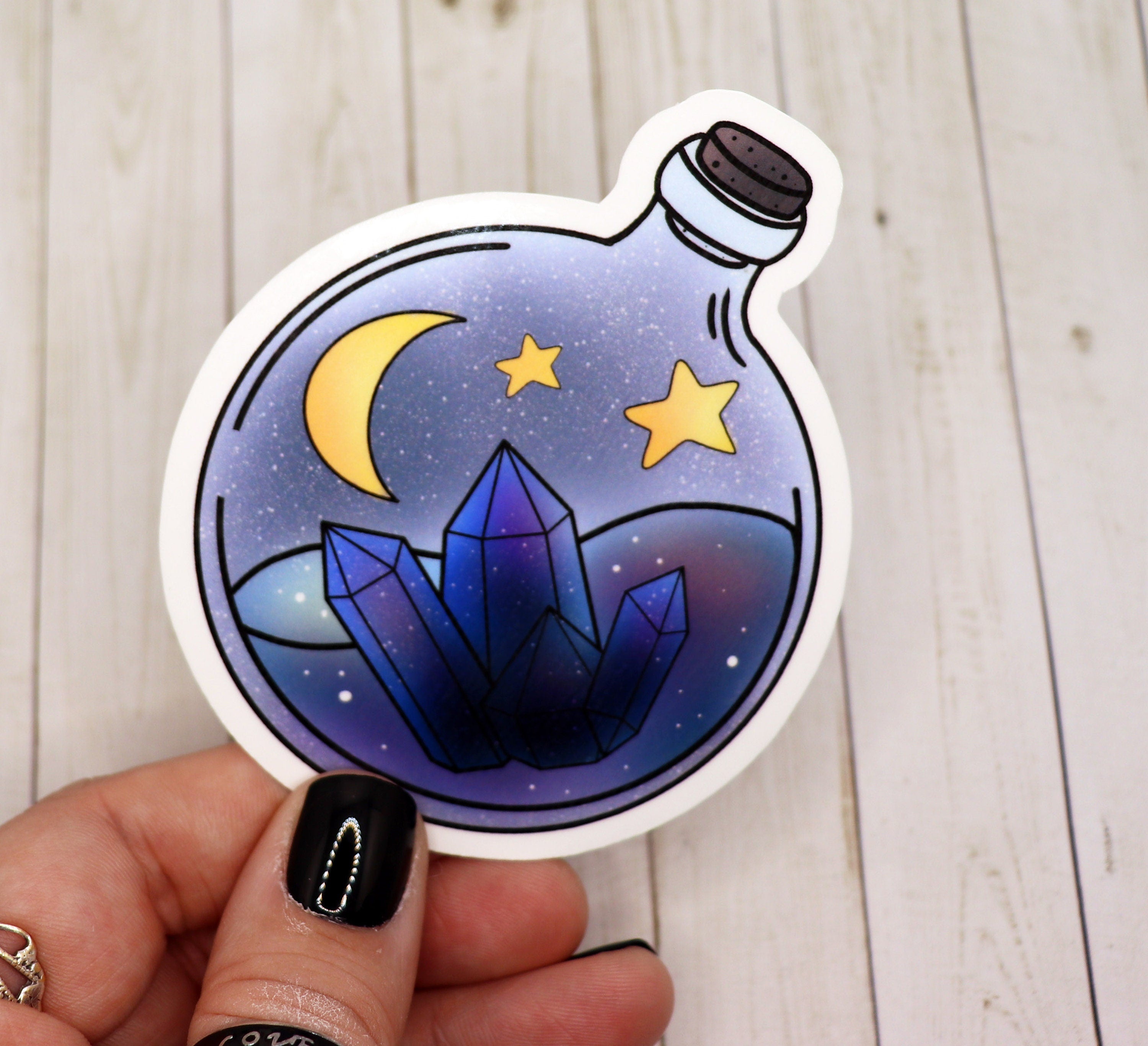 Blue Crystal and Moon Potion Bottle Sticker on a white background, showcasing its vibrant design and matte finish.