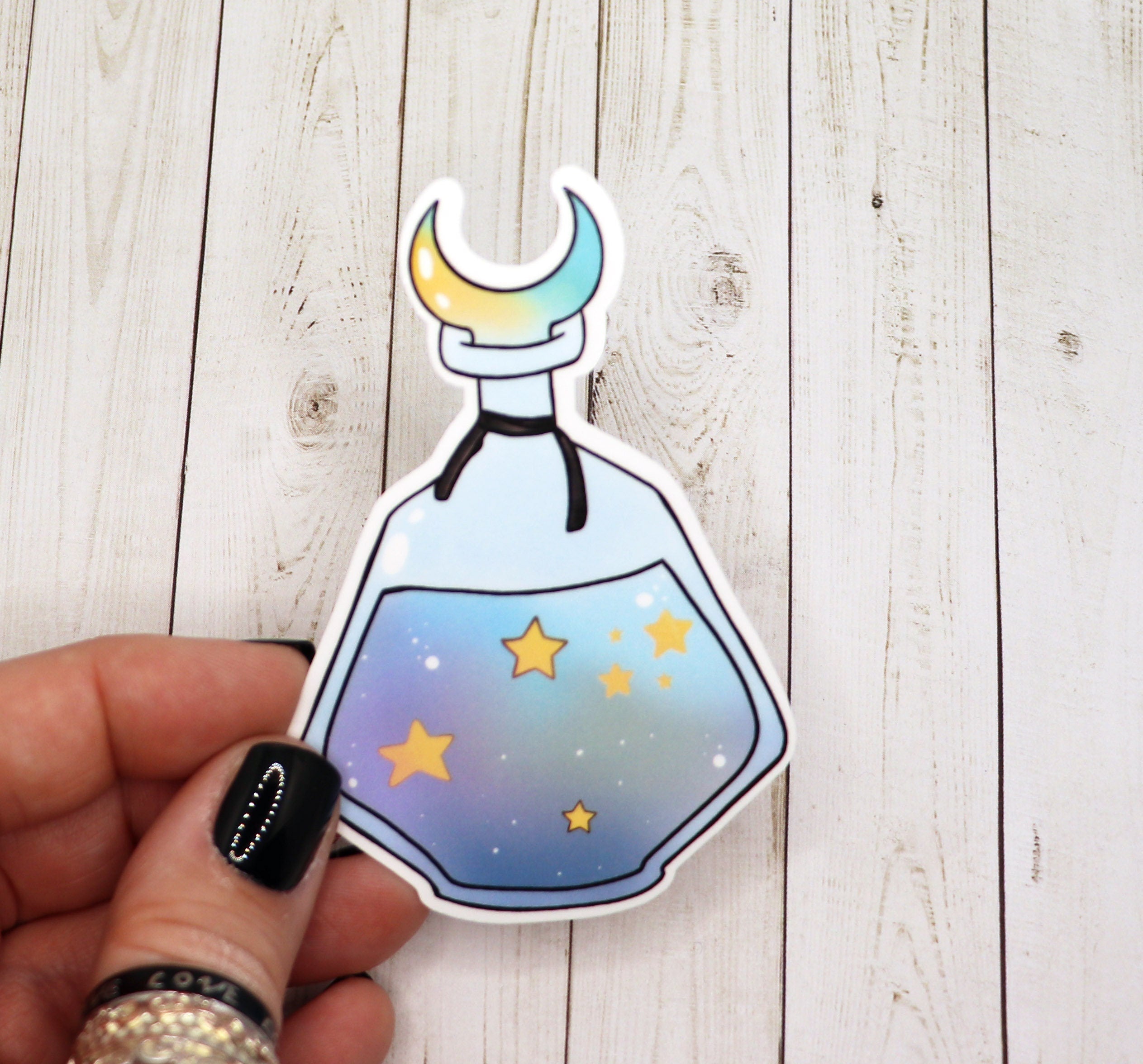 A vibrant blue star potion bottle sticker on a white background, showcasing its intricate design and matte finish.