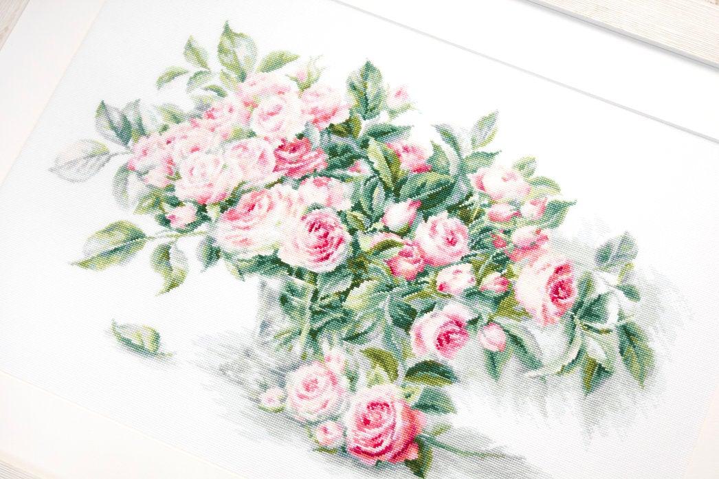 A counted cross-stitch kit featuring a bouquet of pink roses, including canvas, threads, needle, and instructions.