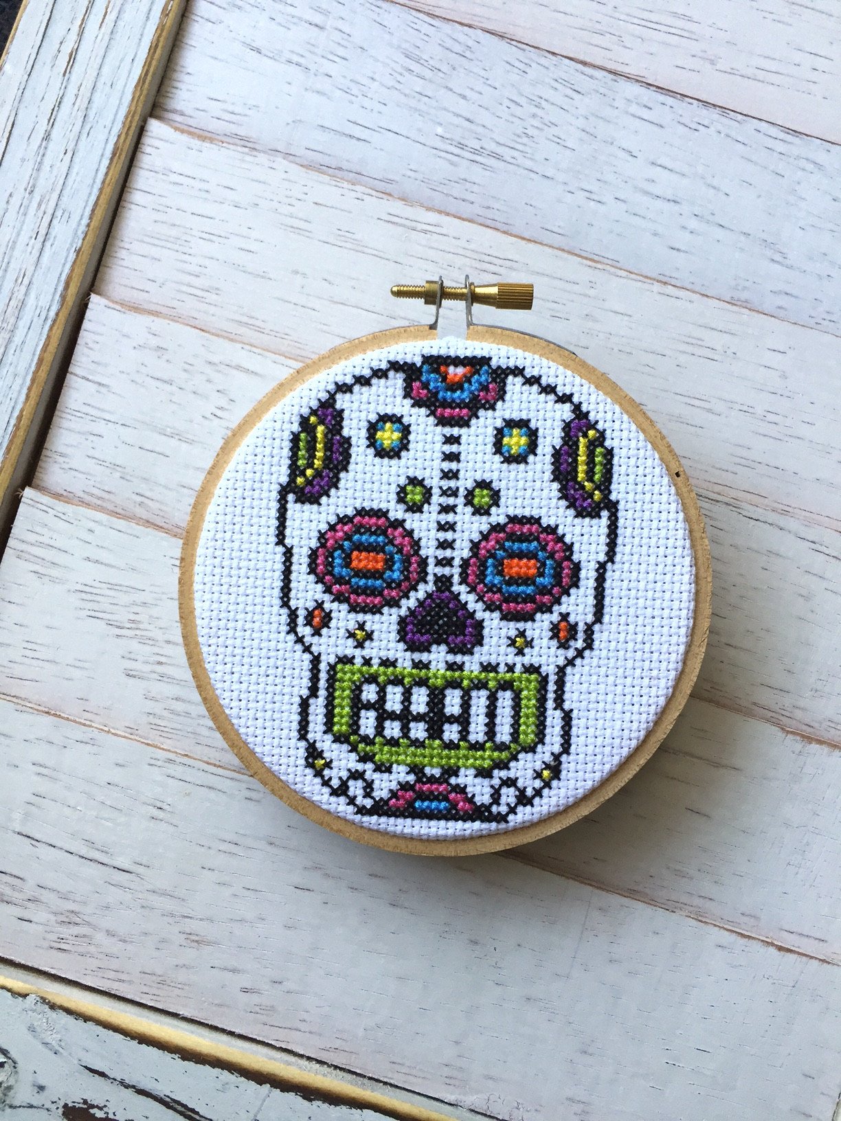 Bright Sugar Skull Counted Cross Stitch DIY Kit with colorful threads and fabric, showcasing a vibrant sugar skull design.