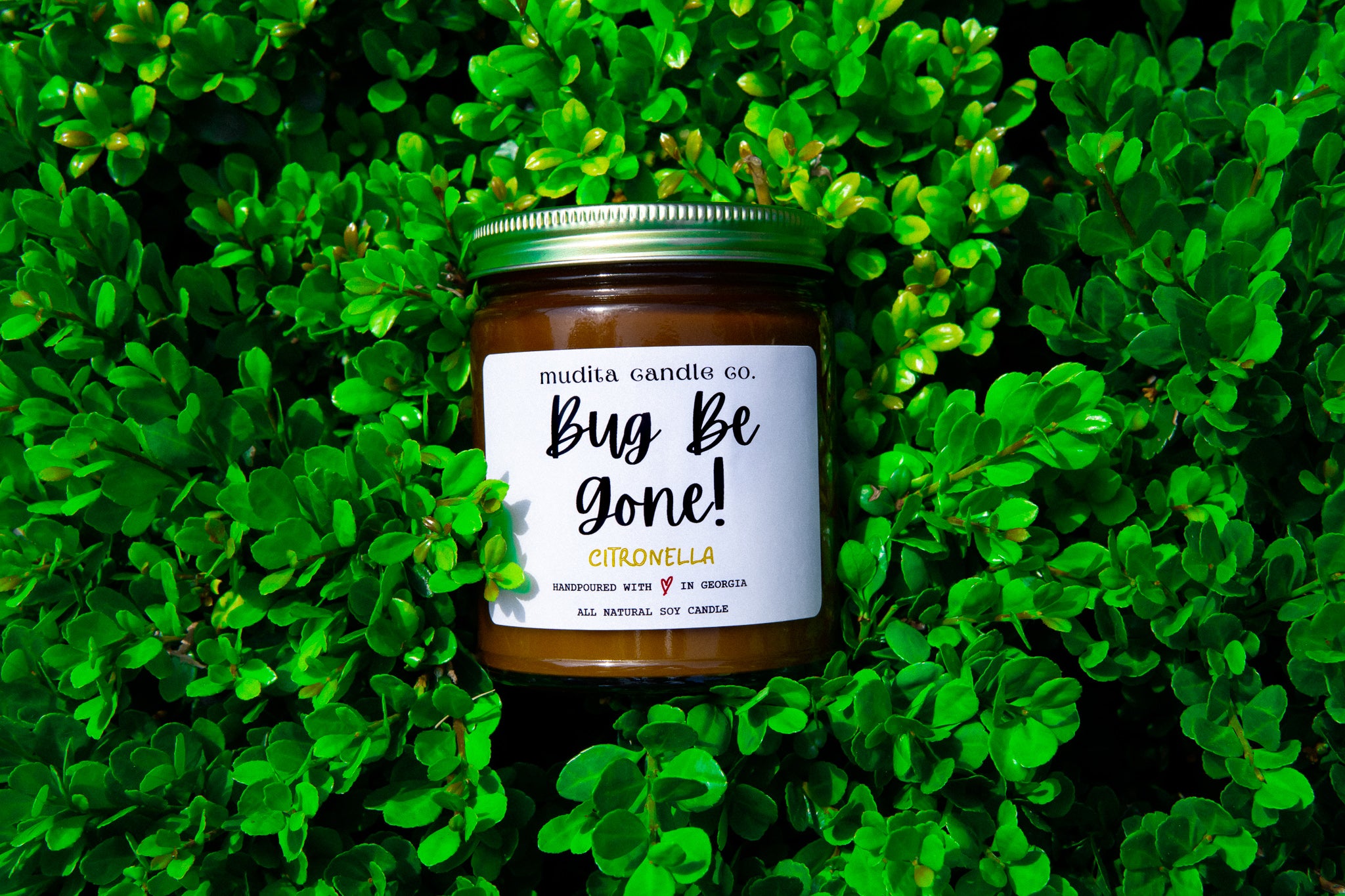 Bug Be Gone! Citronella Soy Candle in a reusable amber glass jar with a gold lid, showcasing its natural ingredients and refreshing scent.