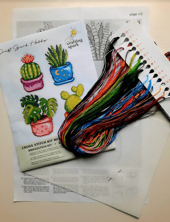 Cactus 108CS Counted Cross-Stitch Kit featuring plastic canvas, colorful threads, and a needle for crafting.