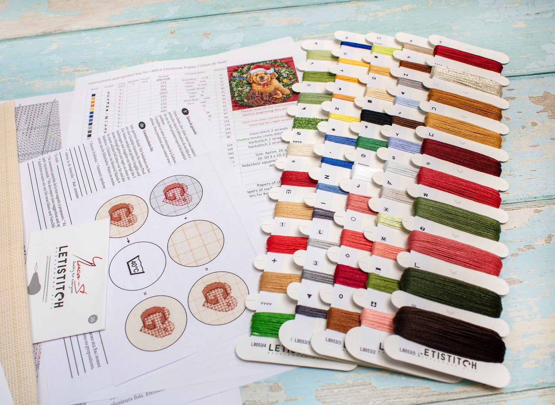 Christmas Puppy Counted Cross Stitch Kit featuring a festive design with 54 colors, needle, and instructions on 16-count Aida canvas.