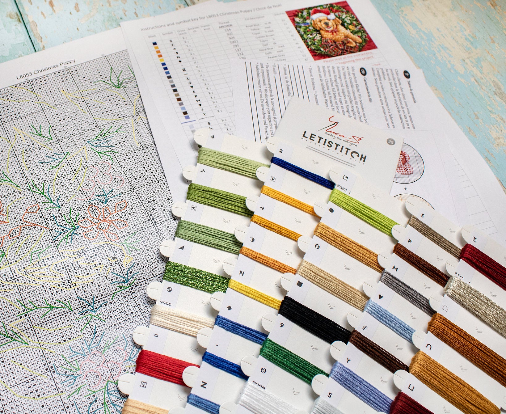 Christmas Puppy Counted Cross Stitch Kit featuring a festive design with 54 colors, needle, and instructions on 16-count Aida canvas.