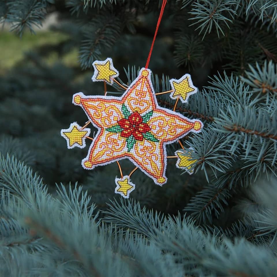 Christmas tree toy plastic canvas cross-stitch kit with colorful threads and materials for crafting.