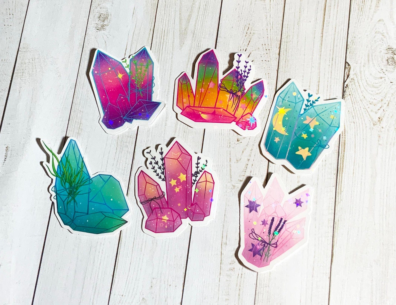 A vibrant pack of colorful crystal stickers featuring six unique designs on matte vinyl, showcasing their glossy laminated finish.