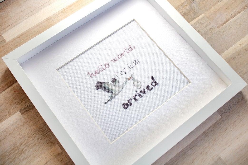 Counted cross stitch kit for newborns featuring canvas, threads, needle, and instructions.