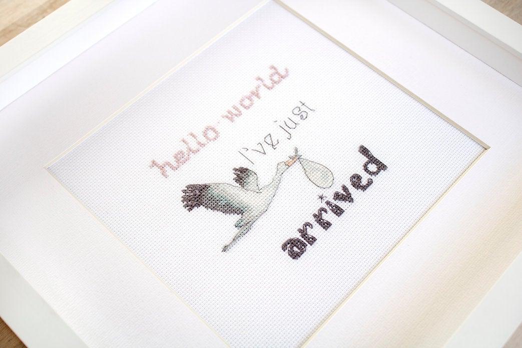 Counted cross stitch kit for newborns featuring canvas, threads, needle, and instructions.