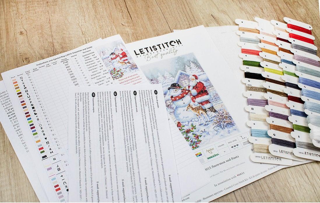Counted Cross Stitch Kit featuring a Snowman and Santa design, including colorful threads and a needle on a canvas.