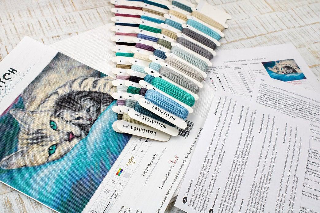 Counted Cross Stitch Kit Tucked In L8020 featuring vibrant threads, Aida canvas, and included needle and instructions.