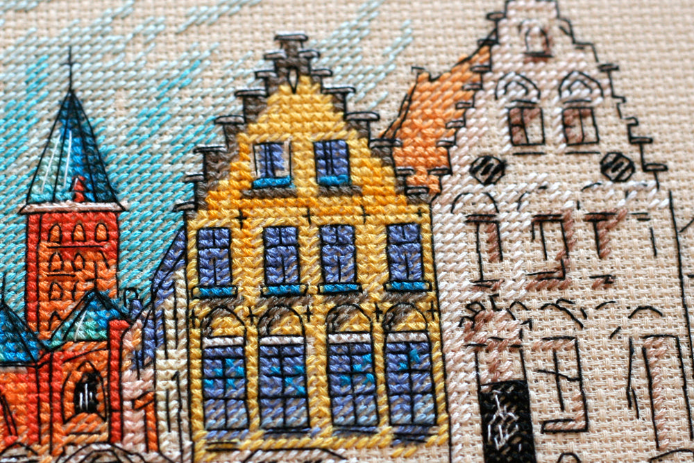 Cross-stitch kit Colored town-1 AH-137 featuring a beige canvas, 23 colorful floss threads, and organized stitching materials.