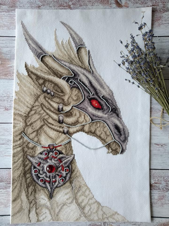 Cross-stitch kit M-319C 'Guardian of treasure' featuring colorful threads, beads, and Aida fabric.