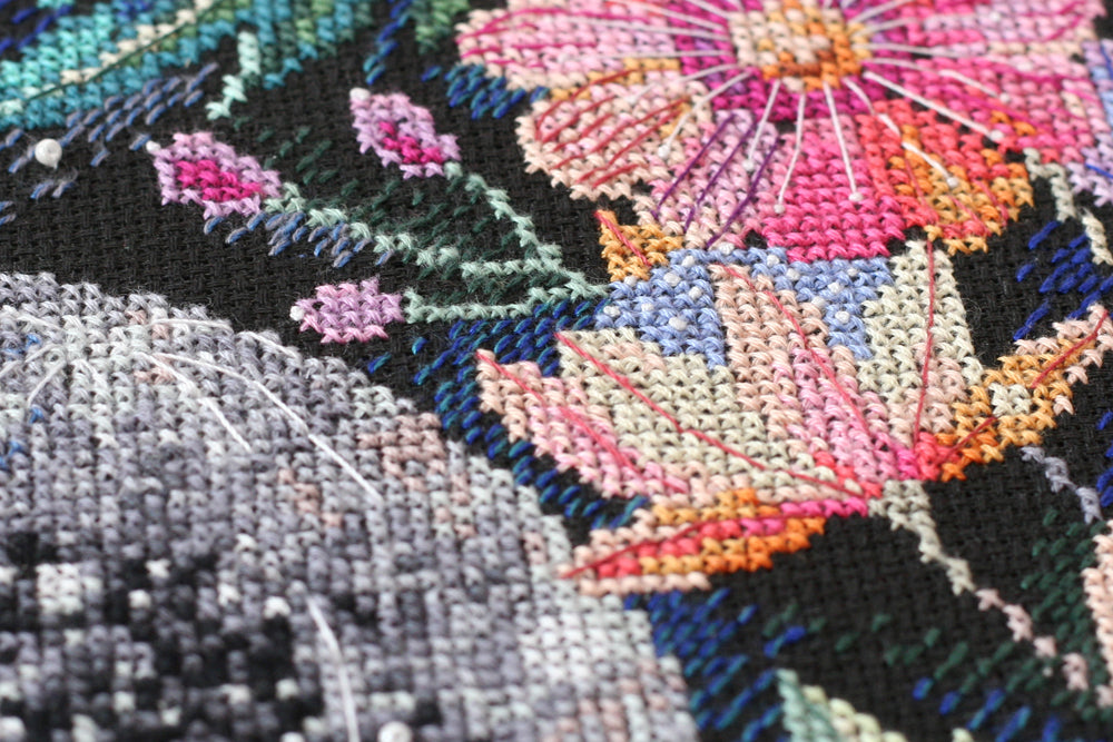 Cross-stitch kit Moon secrets AH-065 featuring black canvas, colorful floss, beads, and needles for crafting.