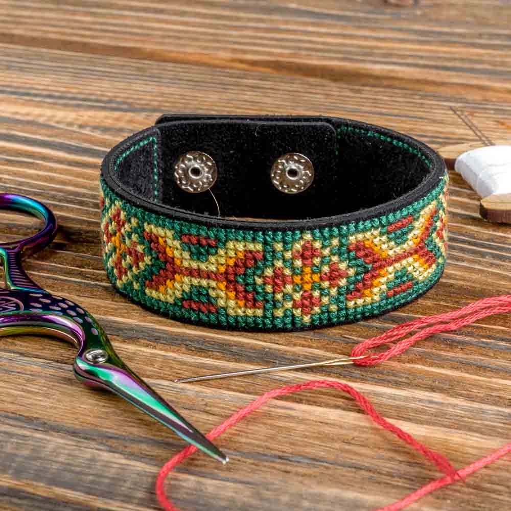 Cross-stitch kit on artificial leather FLHL-030 with materials for creating embroidered bracelets, including leather blanks and cotton floss.