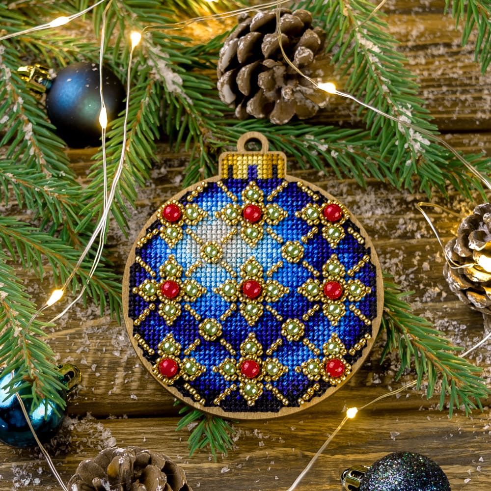Cross-stitch kit FLW-008 featuring a wooden base, colorful threads, beads, and all necessary tools for creating Christmas decorations.