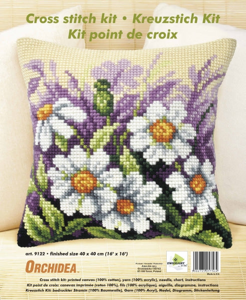 Cushion cross stitch kit featuring white flowers on a meadow, including printed canvas, yarn, needle, and instructions.