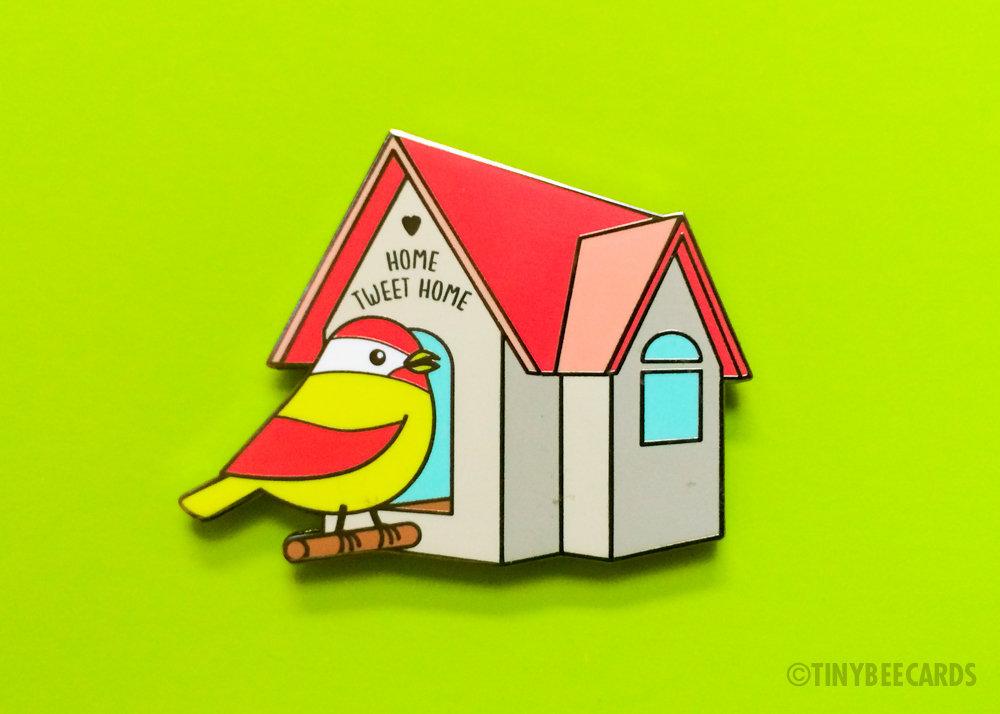 Cute Bird Hard Enamel Pin featuring a yellow and pink bird next to a birdhouse with the text 'Home Tweet Home'.