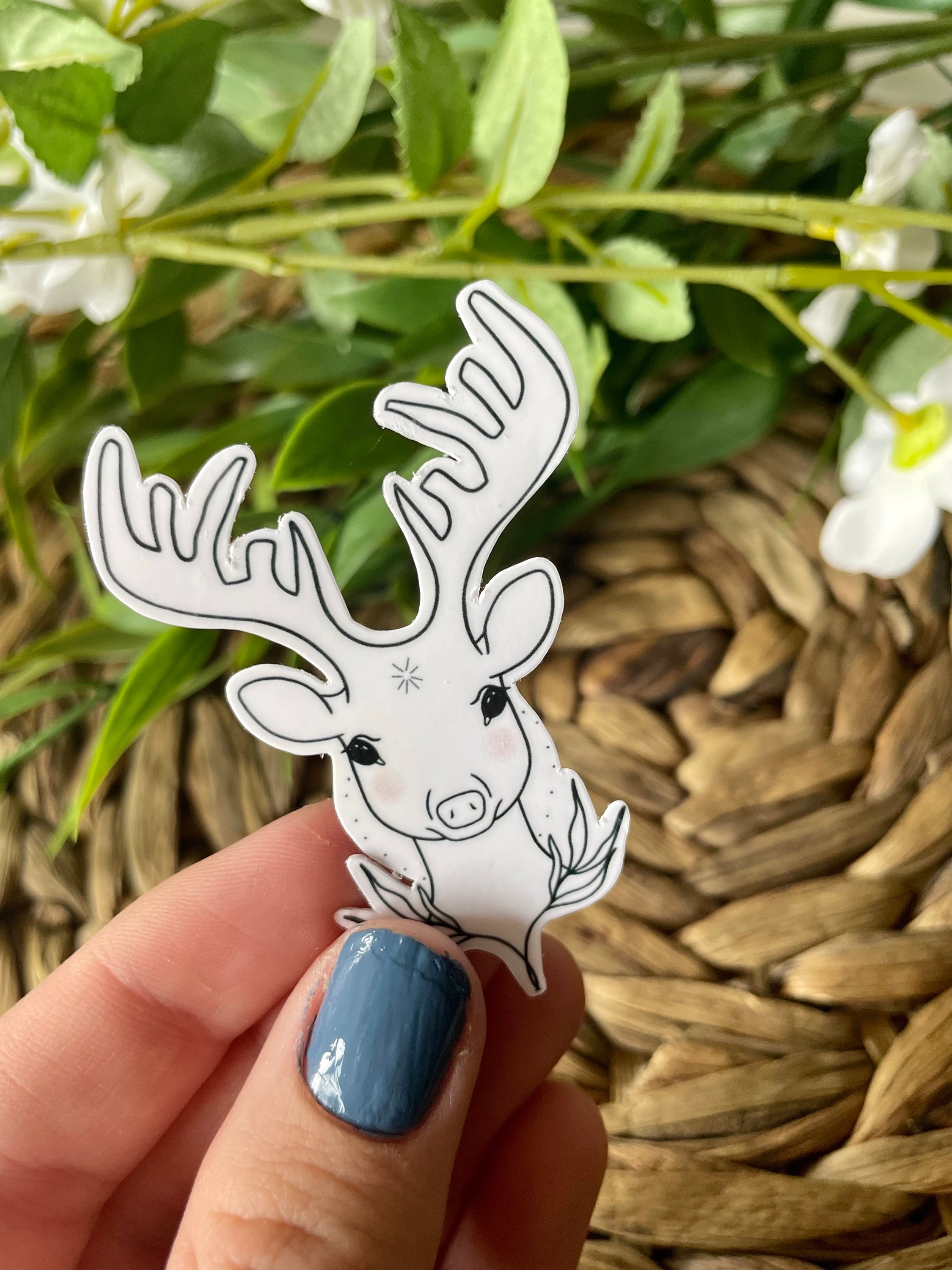 Hand holding a deer sticker.