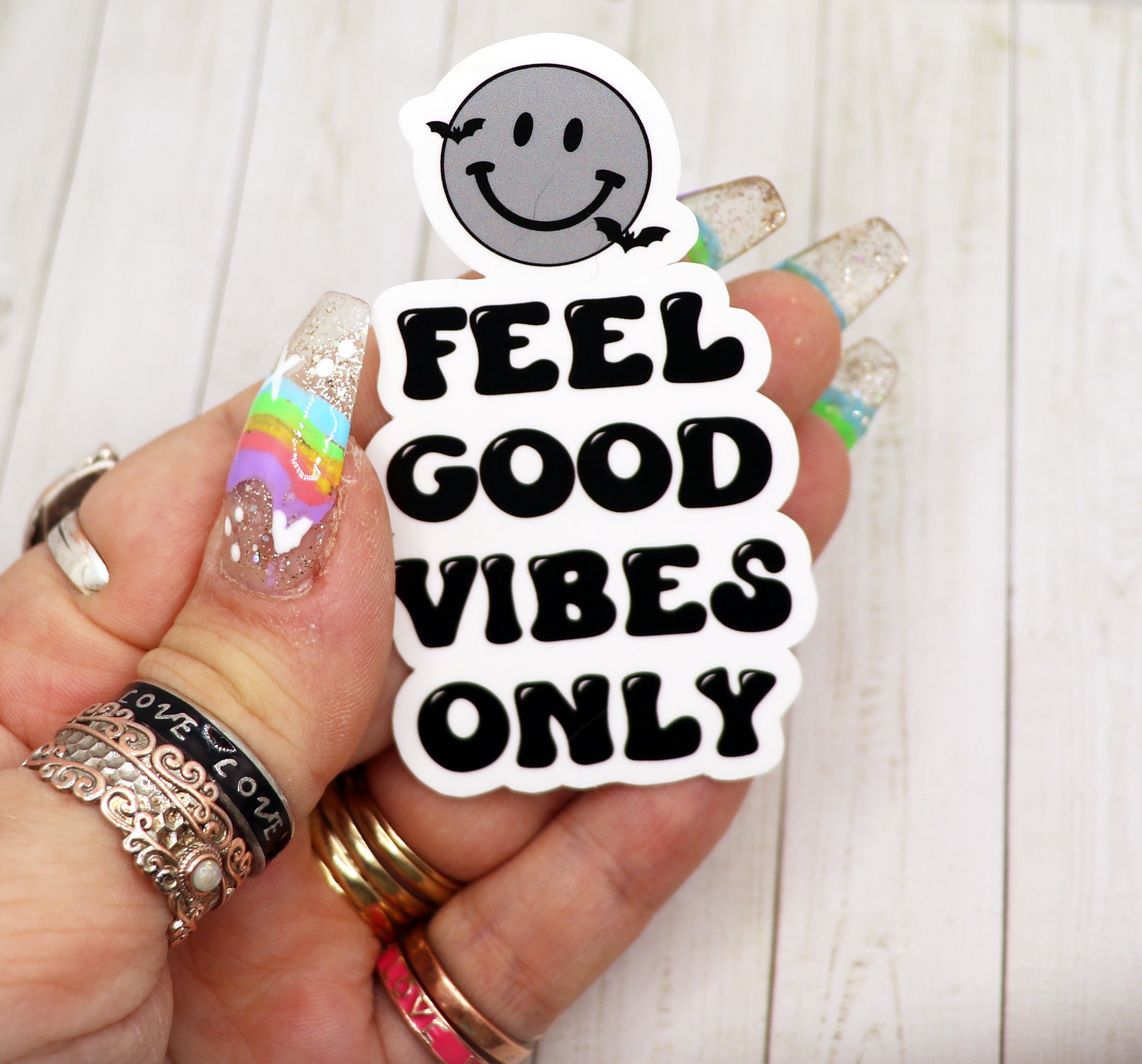 A vibrant vinyl sticker featuring a cheerful smiley face with the text 'Feel Good Vibes Only', perfect for personalizing various items.