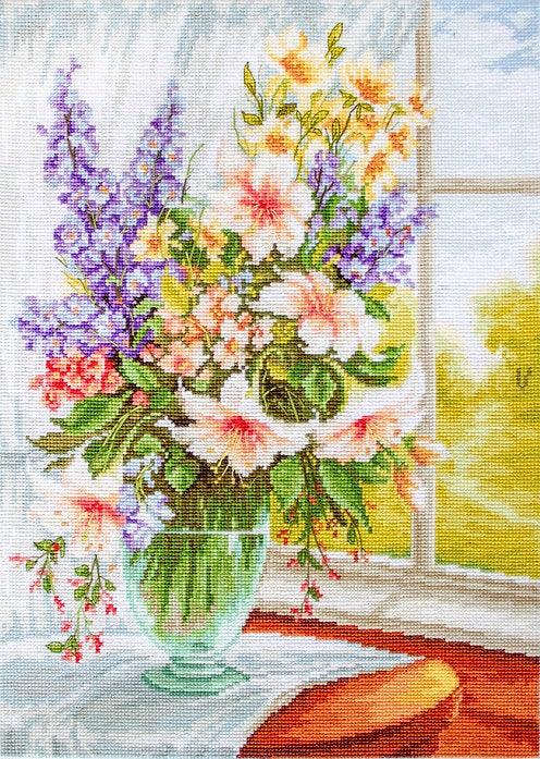 Counted cross-stitch kit featuring soft flowers at a window, including Aida canvas, threads, needle, and instructions.