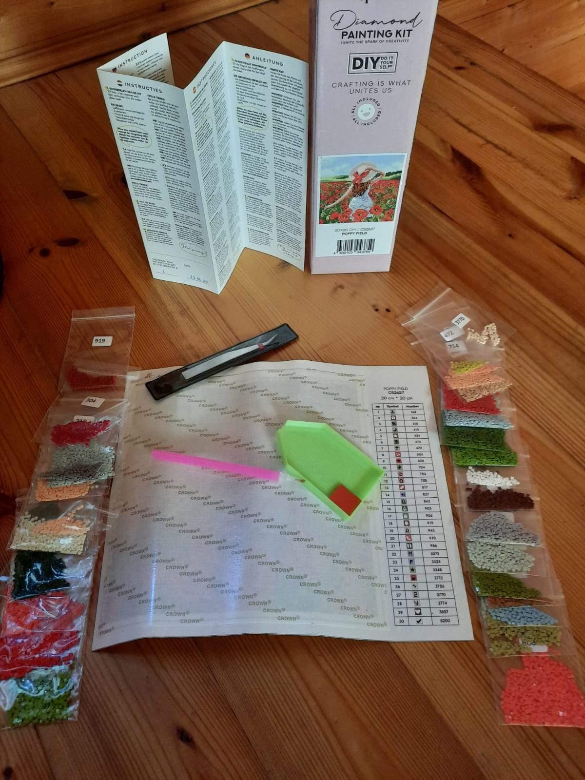 A vibrant diamond painting kit featuring a girl in a sunflower field, including tools and pre-sorted acrylic diamonds.