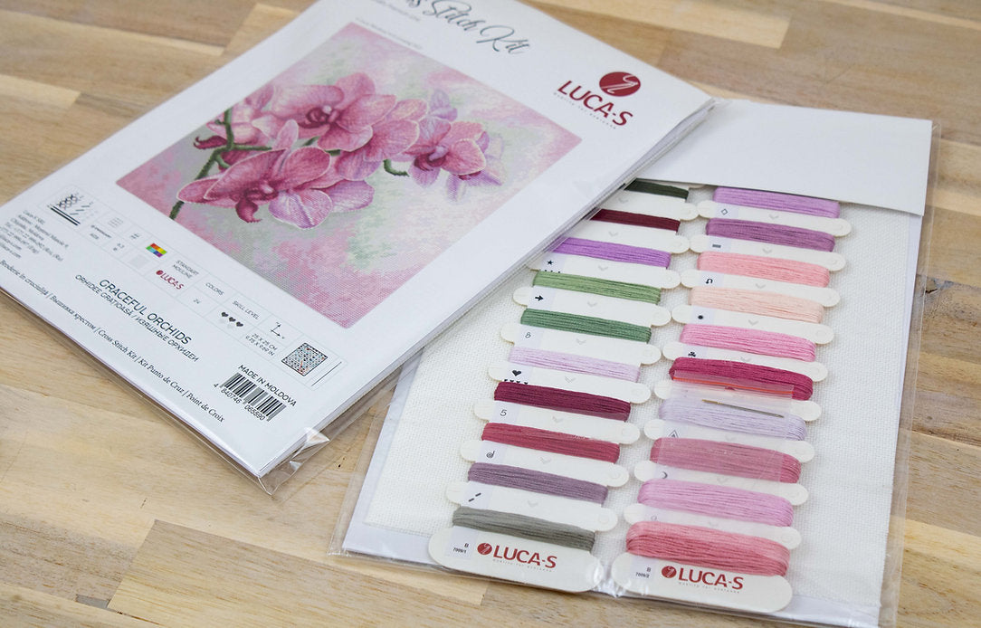 Graceful Orchids B7009L Counted Cross-Stitch Kit featuring vibrant threads, Aida canvas, and a needle for crafting.