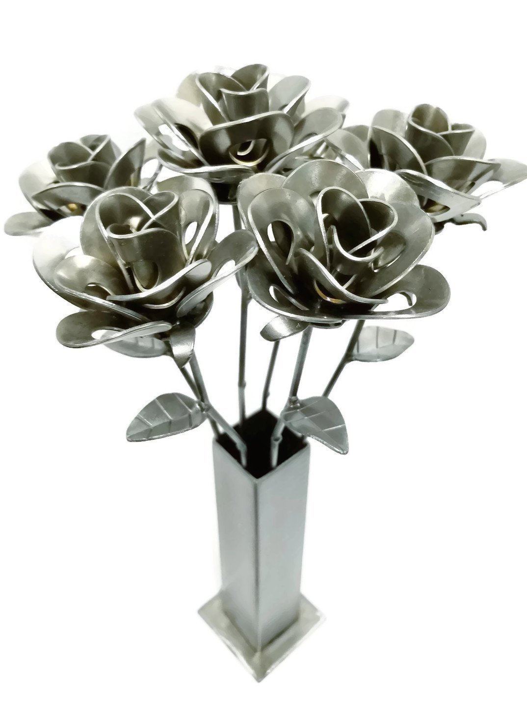 A beautiful arrangement of six handcrafted metal roses made from recycled materials, displayed in a rustic vase, showcasing unique artistic details.