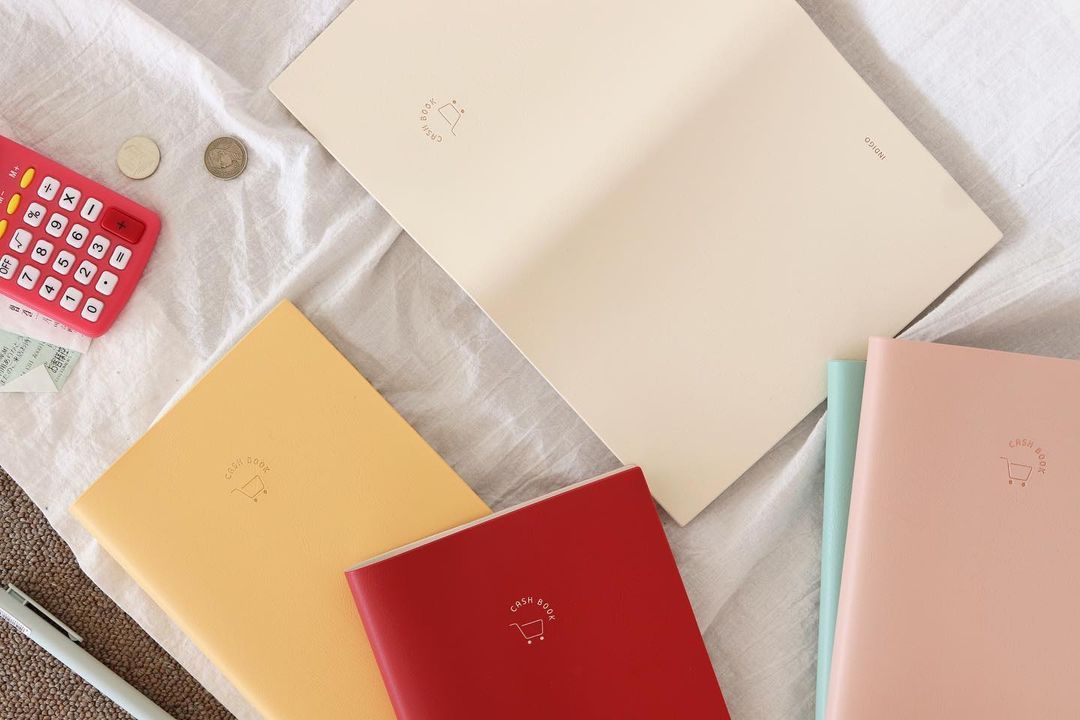 INDIGO SIMPLE CASH BOOK featuring a stylish cover and undated pages for tracking expenses over 12 months.