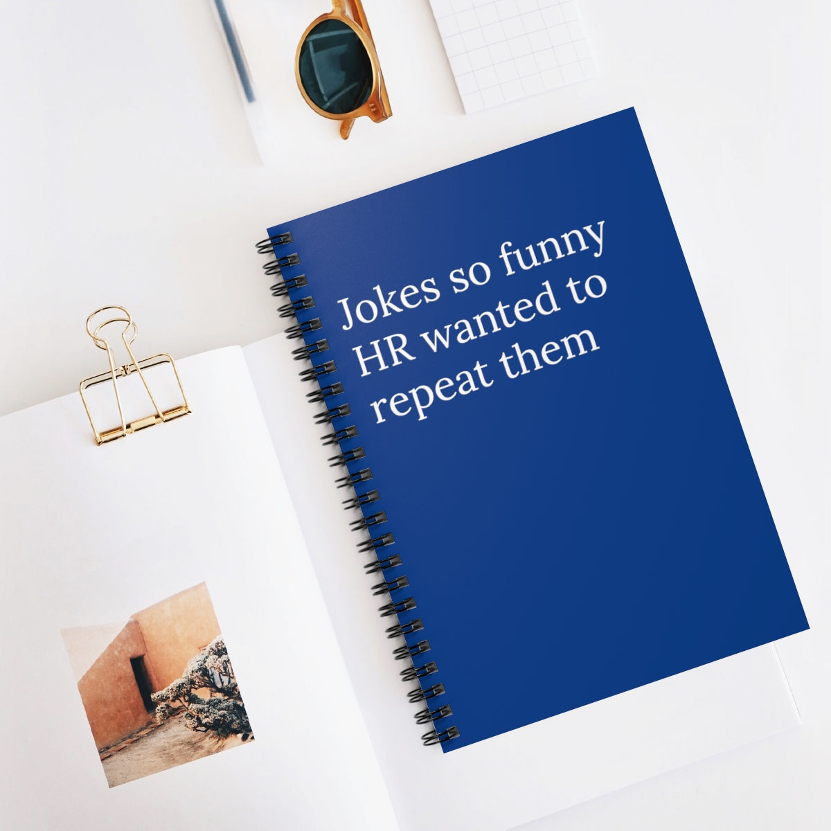 A humorous spiral notebook titled 'Jokes So Funny HR Wanted to Repeat Them', featuring ruled line pages and a playful design.