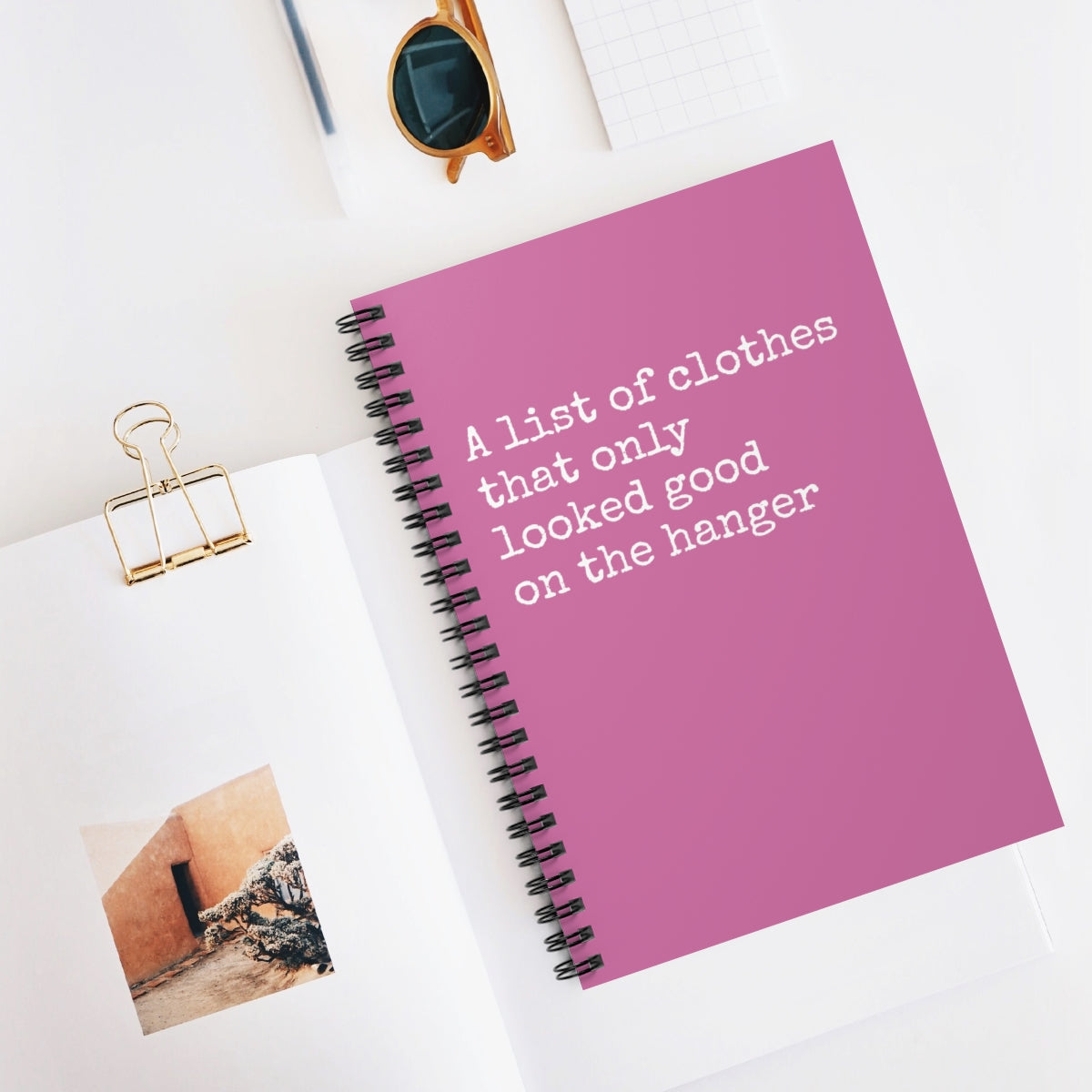 Spiral notebook with ruled pages, titled 'List of Clothes that Only Looked Good on the Hanger', ideal for outfit organization.