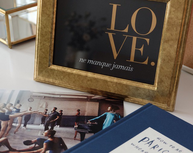 Art print featuring 'Love Never Fails' in French with gold foil accents on colored stock, size 30x40cm.