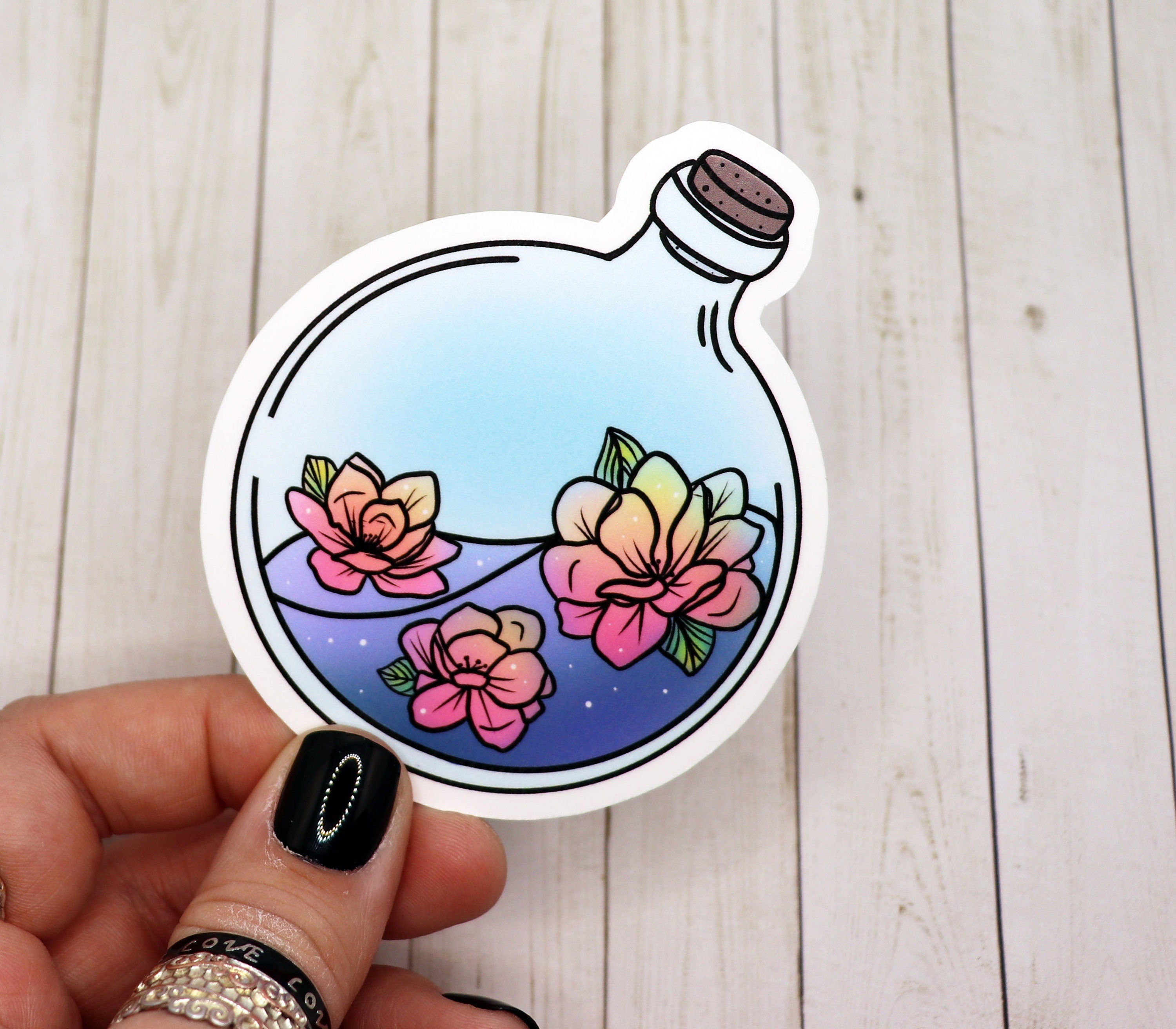A vibrant Magnolia potion bottle sticker featuring intricate design details, perfect for personalizing various items.
